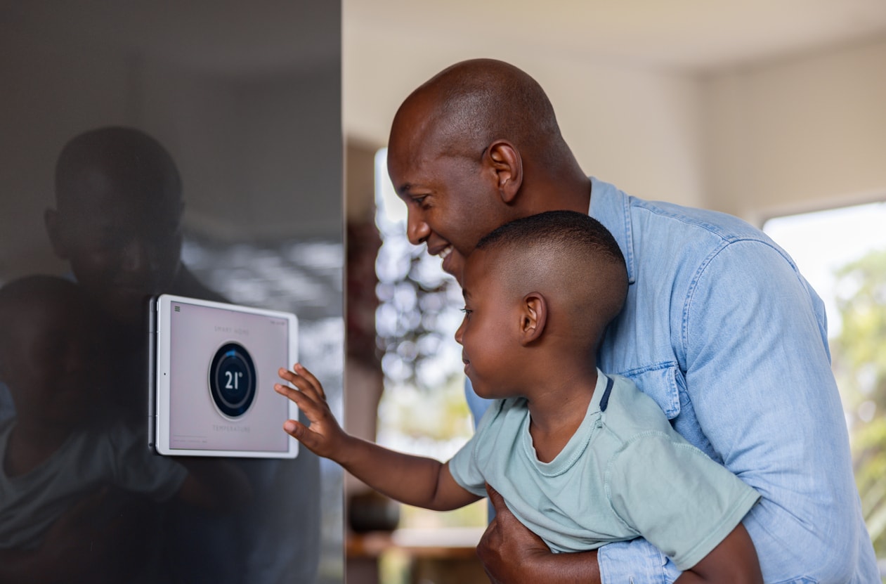 A father and son learn how to use an air conditioning panel control.